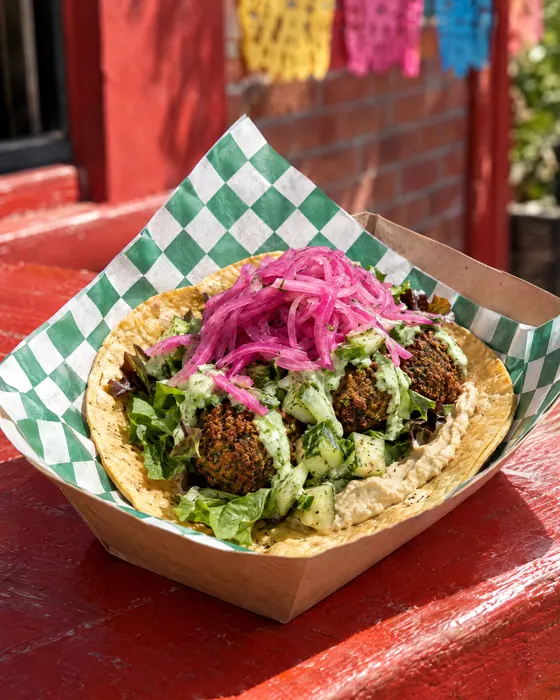 El Arabic Taco with falafel, greens and pickled onions.