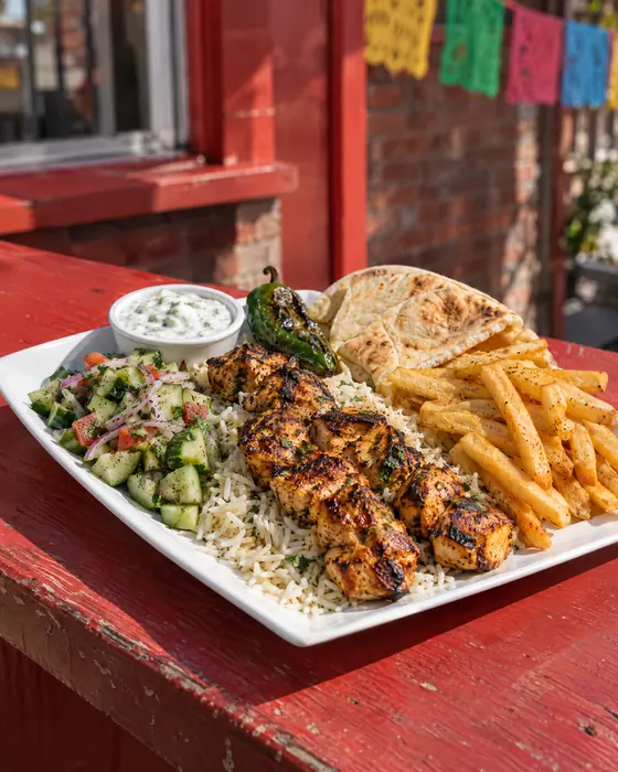 Kebab plate with chicken kebab, rice, pita, tzatziki and fries.
