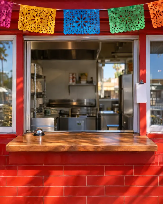 The open service window with a bell on the counter.